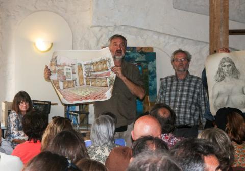 André Rives présente un dessin lors de la vente aux enchères qu'il a organisée.